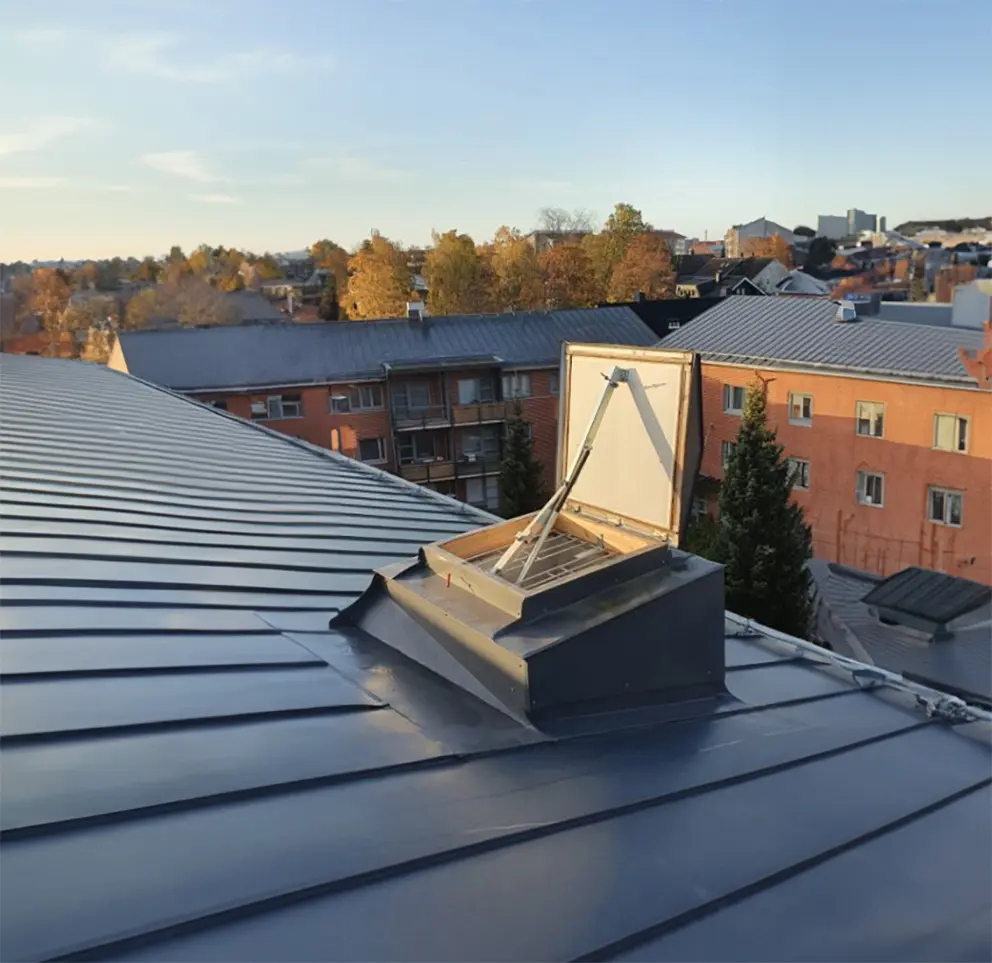 Kerrostalon kaasujousitoiminen savunpoistoluukku avonaisena katolla